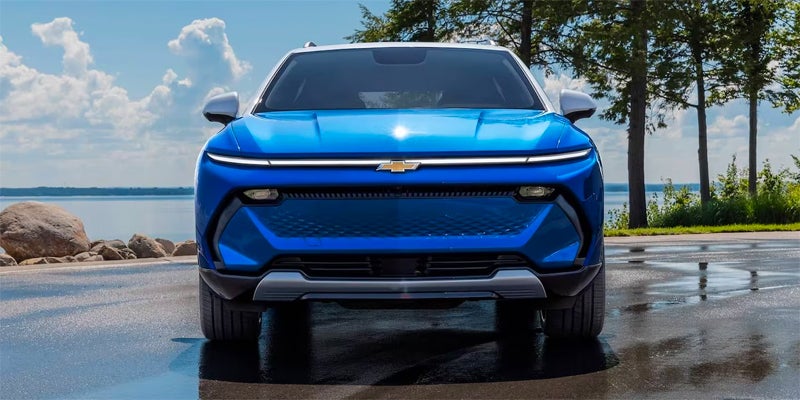 Blue electric SUV driving on beach