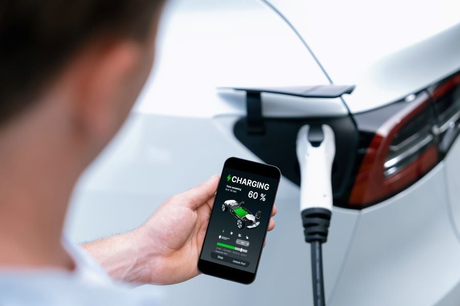 Man monitoring EV charging via smartphone app